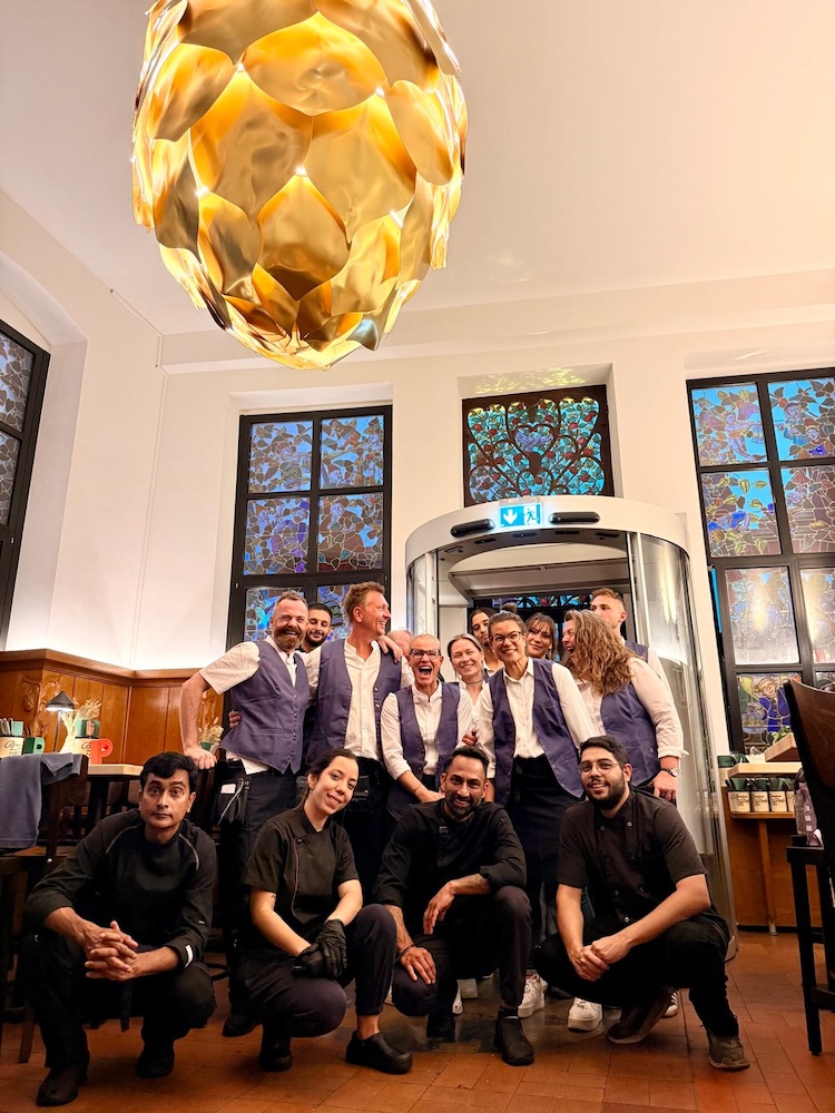 Service- und Küchenteam im Brauhaus zum Pfaffen, Gruppenfoto im Gastraum vor Buntglasfenstern